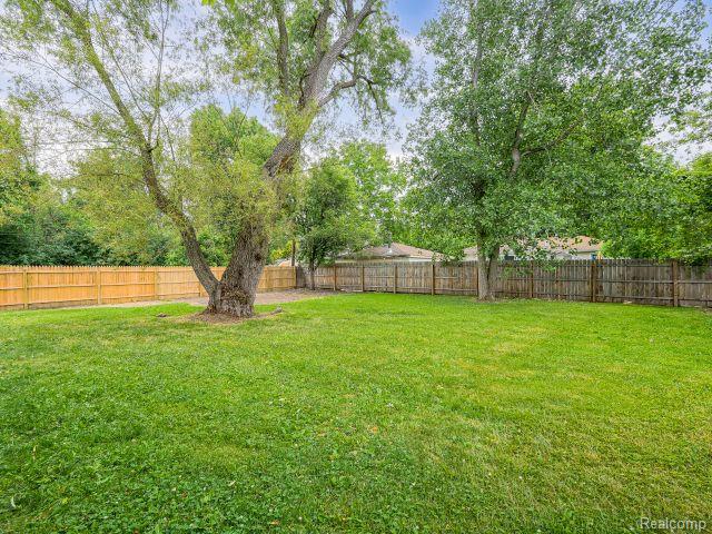 21728 Ruth Street Farmington, MI 48336 - Photo 54 of 54 Spacious backyard featuring a large established tree, mature perimeter trees, a full wood fence, and expansive lawn space