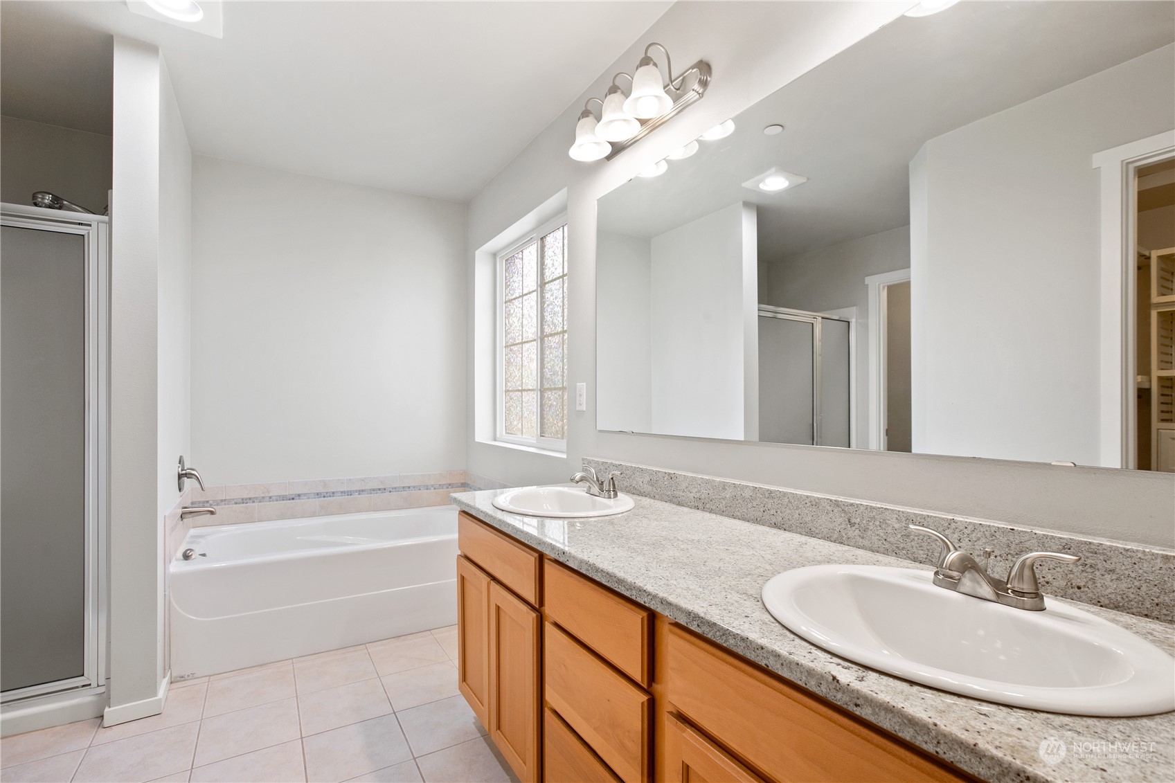 20734 76th Avenue West, Unit D Edmonds, WA 98026 - Photo 20 of 32 a bathroom with a granite countertop bathtub a sink and a mirror