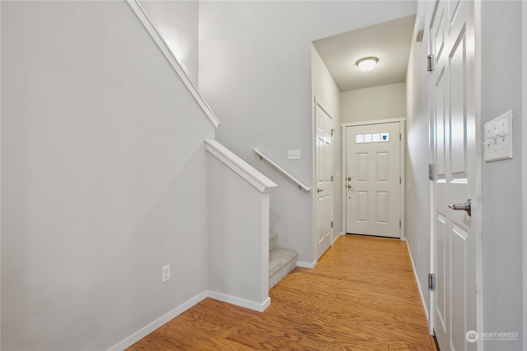 20734 76th Avenue West, Unit D Edmonds, WA 98026 - Photo 3 of 32 a view of a hallway with wooden floor and staircase