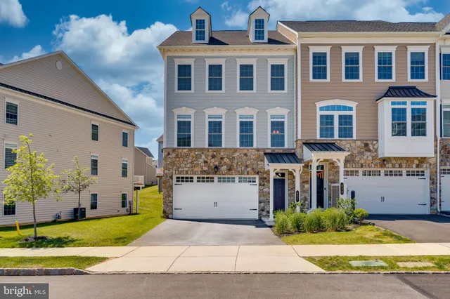 a front view of a house with a garden and plants