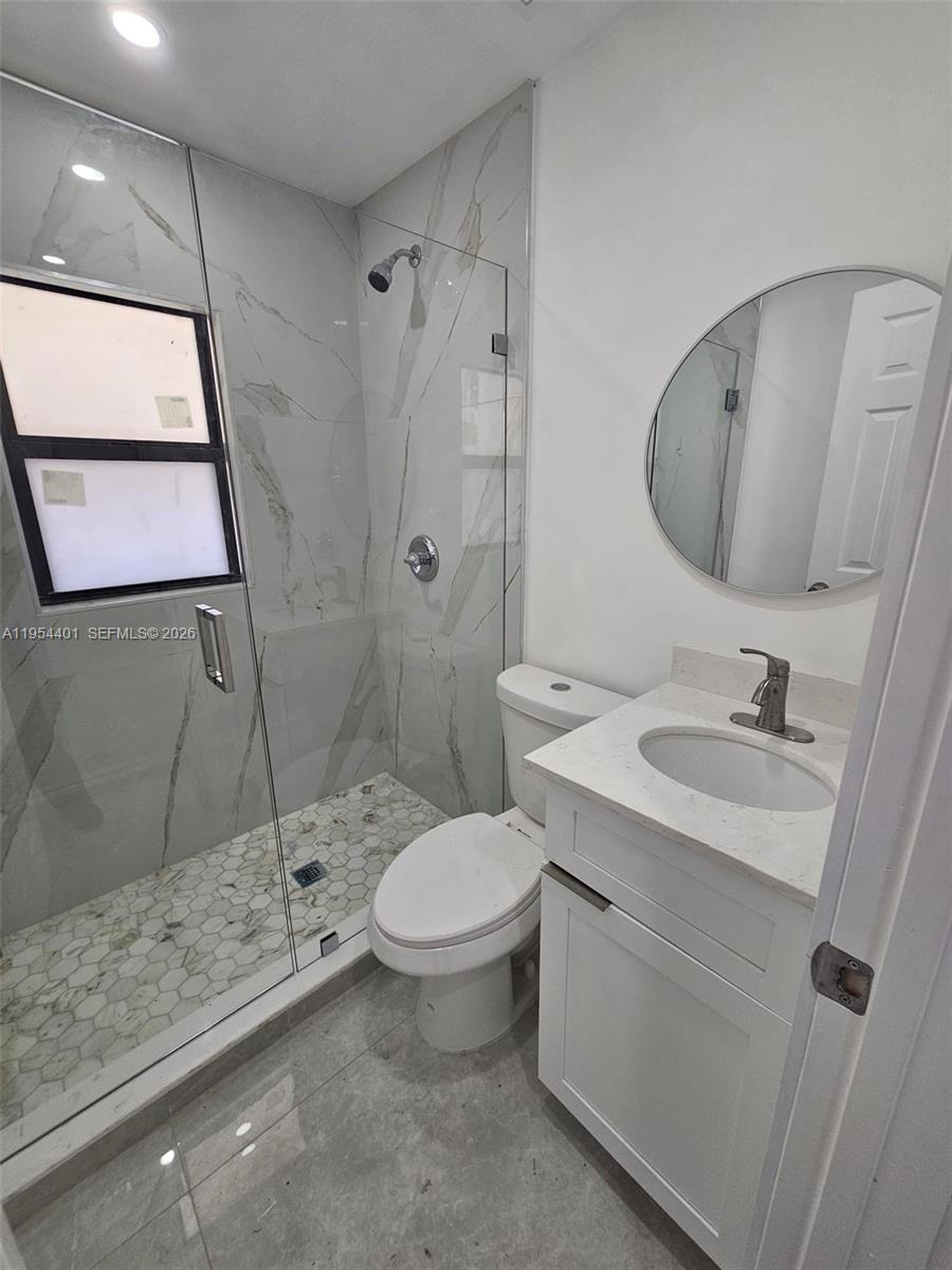 1148 Northwest 100th Street, Unit 2 Miami, FL 33150 - Photo 13 of 22 a bathroom with a granite countertop sink toilet and shower