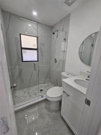 a bathroom with a granite countertop sink toilet and shower