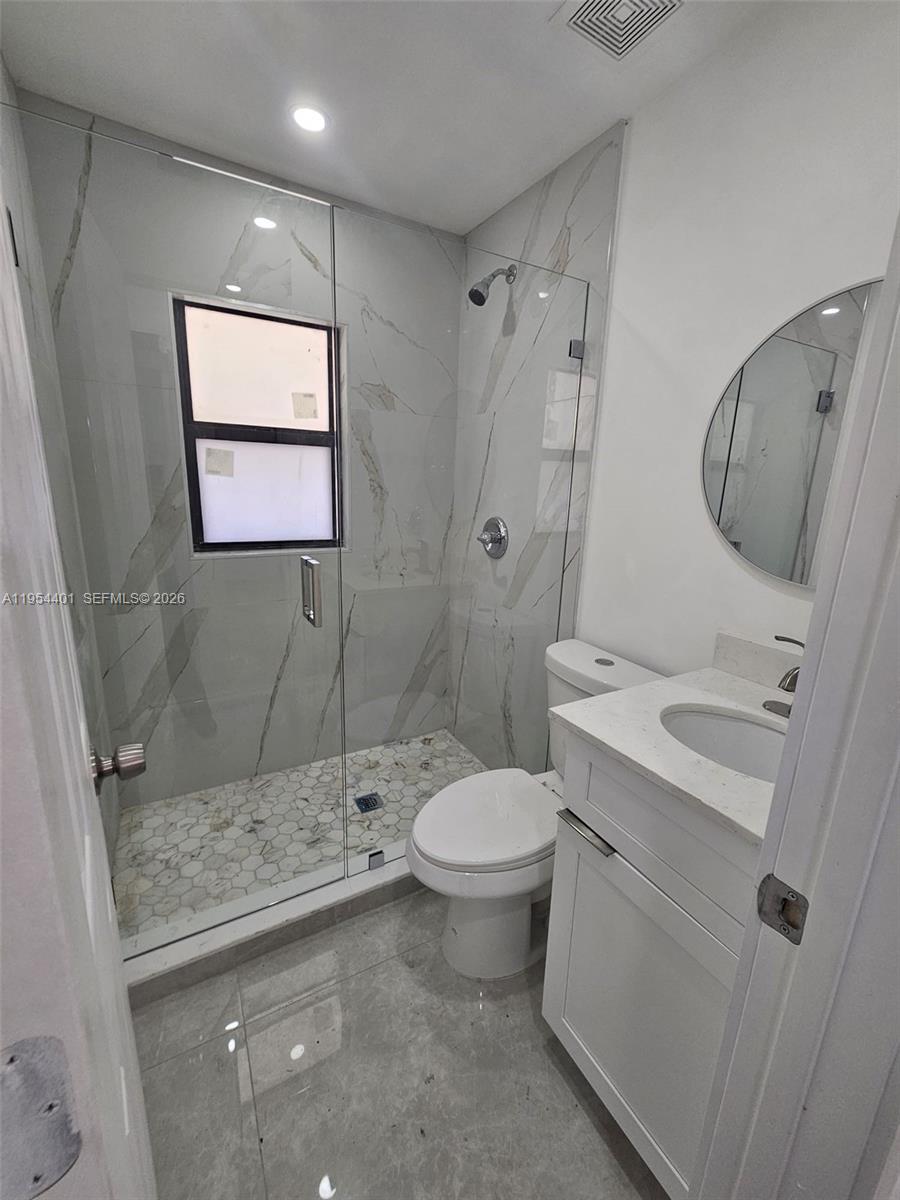 1148 Northwest 100th Street, Unit 2 Miami, FL 33150 - Photo 14 of 22 a bathroom with a granite countertop sink toilet and shower