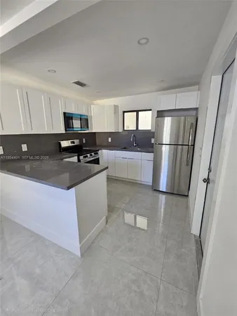 a kitchen with stainless steel appliances a refrigerator stove microwave and sink