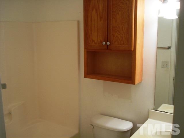 2544 Ross Road Durham, NC 27703 - Photo 15 of 15 a white toilet sitting next to a shower curtain