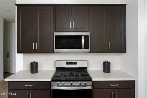 a kitchen with granite countertop a stove and a microwave