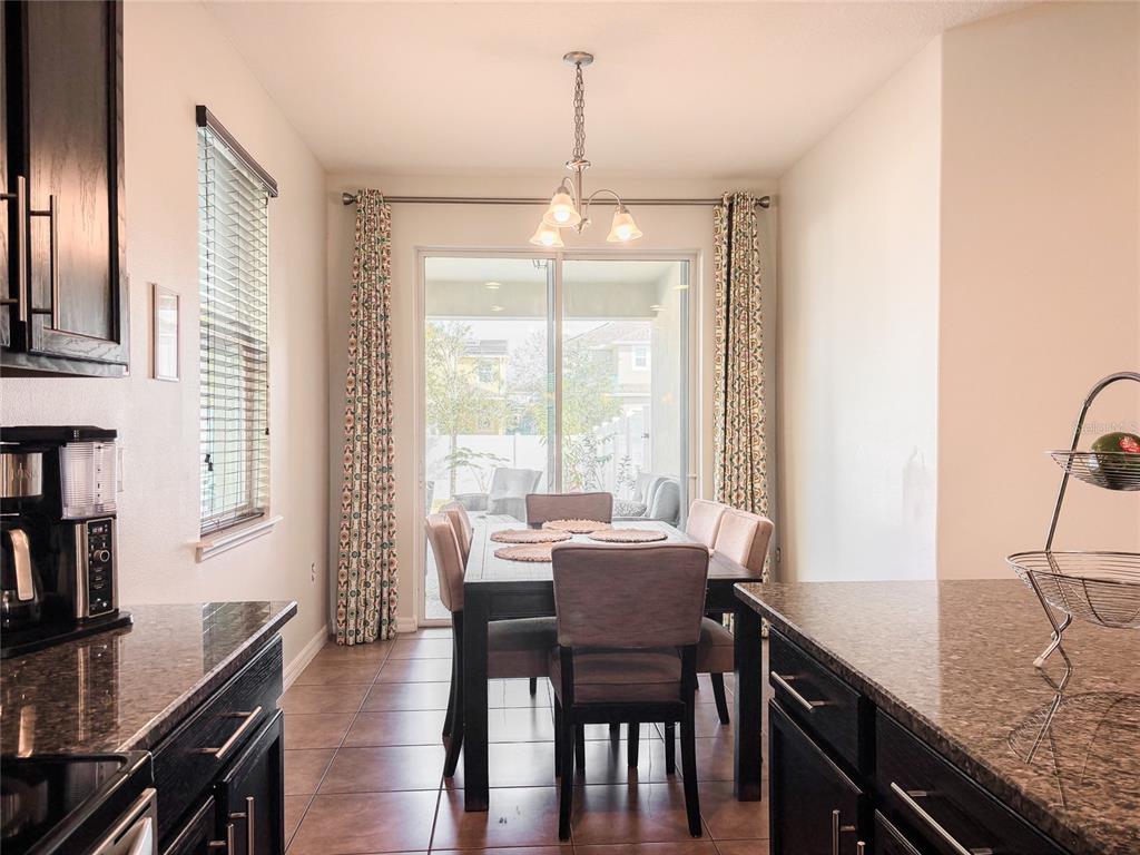 8607 Randal Park Boulevard Orlando, FL 32832 - Photo 15 of 51 a dining room with furniture a chandelier and wooden floor