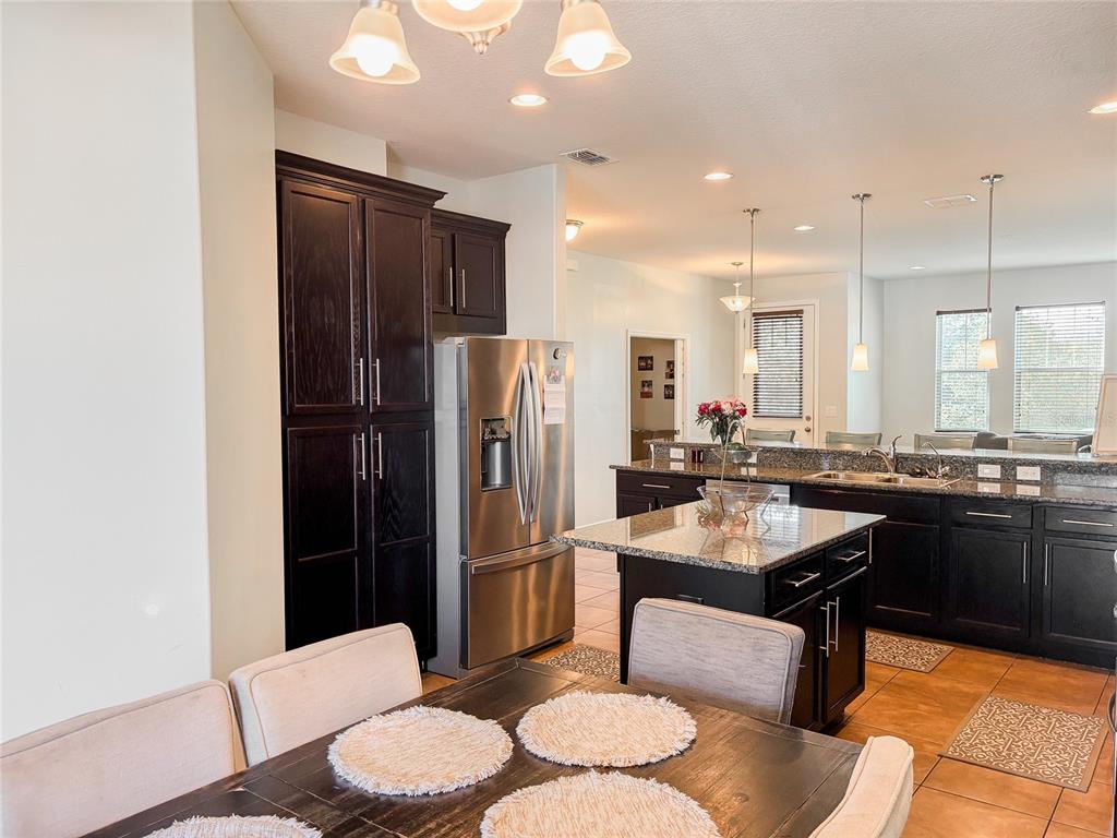 8607 Randal Park Boulevard Orlando, FL 32832 - Photo 23 of 51 a kitchen with a refrigerator a sink and chairs