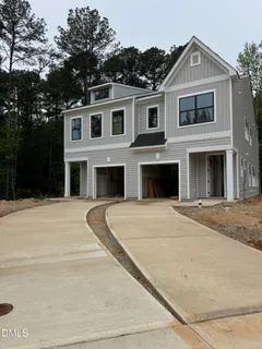 a front view of a house with yard and parking