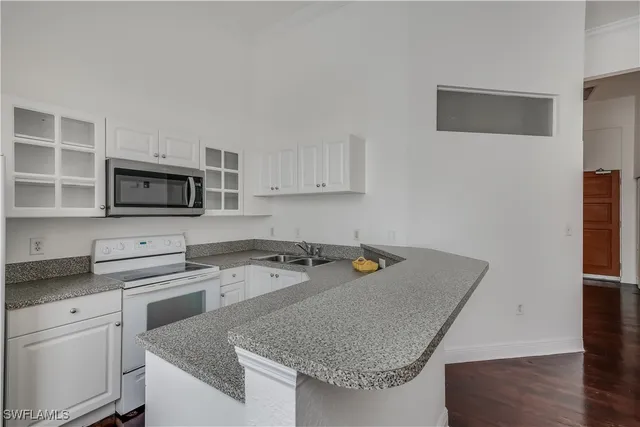 a kitchen with a sink a microwave a refrigerator and cabinets