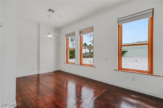 a view of an empty room with chandelier fan
