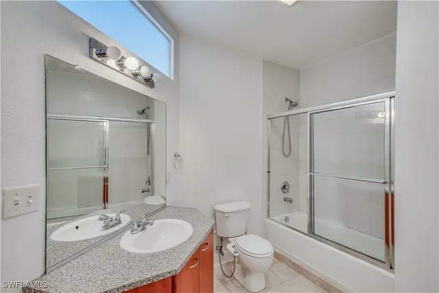 a bathroom with a granite countertop sink toilet a mirror and shower