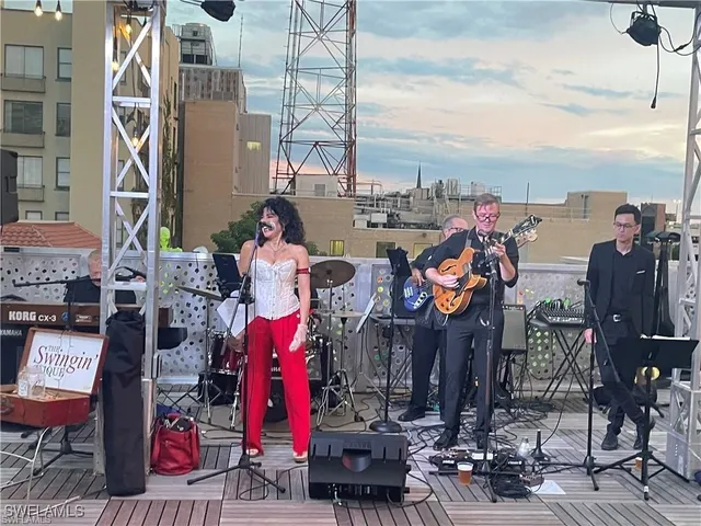 a front view of a building with lots of green space and fountain