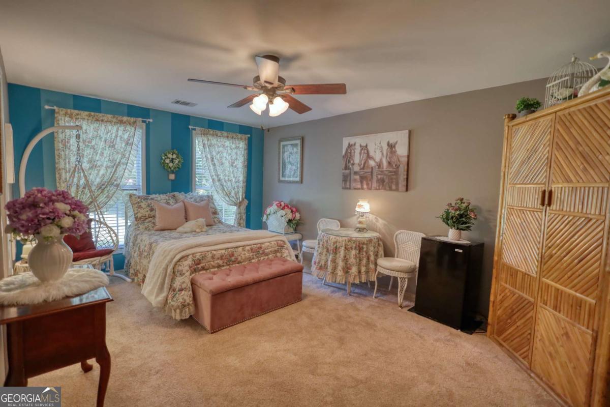 947 Bellhouse Road Macon, GA 31217 - Photo 25 of 100 a spacious bedroom with a bed and a chandelier