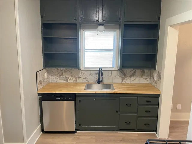 a room with granite countertop a sink and a window