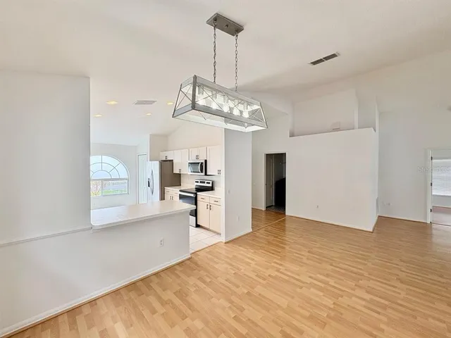 a view of a room with wooden floor and a ceiling fan
