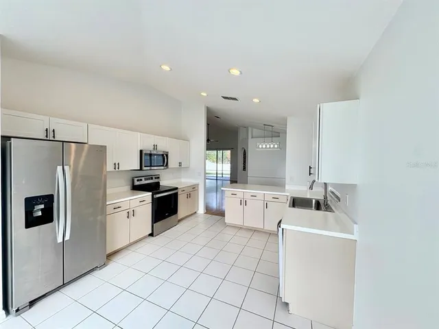 a kitchen with stainless steel appliances a refrigerator sink and microwave