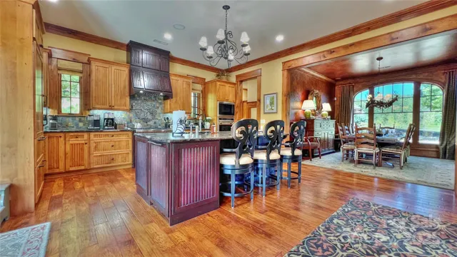 a kitchen with stainless steel appliances granite countertop a stove and a wooden floors