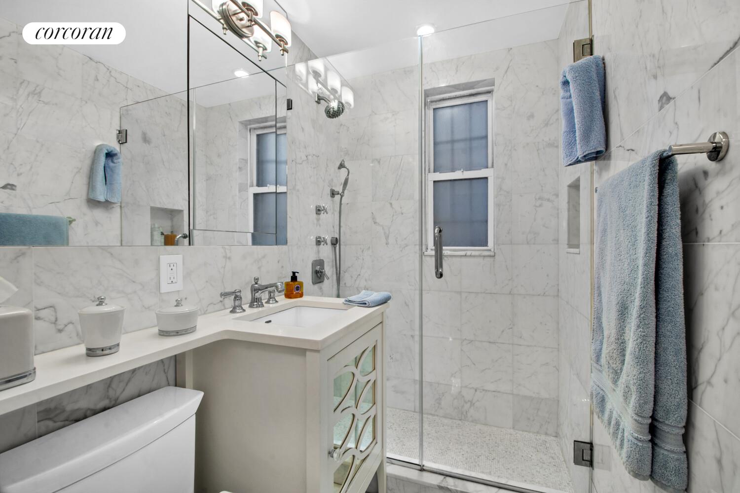 241 East 76th Street, Unit 2HI Manhattan, NY 10021 - Photo 10 of 27 a bathroom with a sink mirror and shower