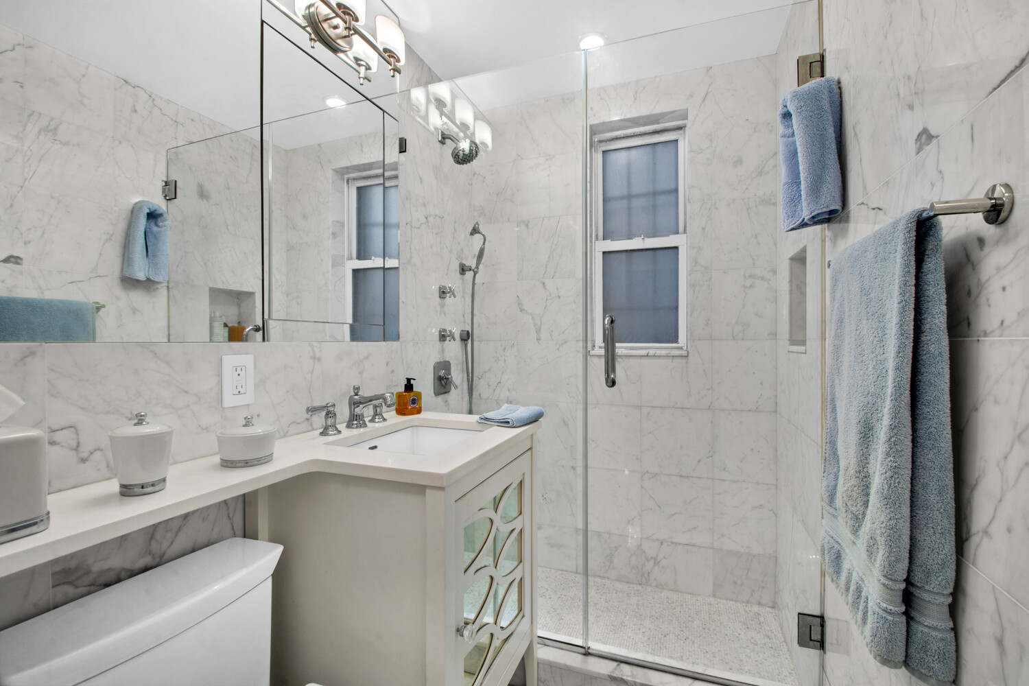 241 East 76th Street, Unit 2HI Manhattan, NY 10021 - Photo 23 of 27 a bathroom with a sink mirror and shower