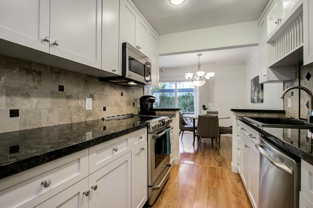1049 Shell Boulevard, Unit 3 Foster City, CA 94404 - Photo 13 of 56 a kitchen with stainless steel appliances granite countertop a sink a stove and a wooden floors