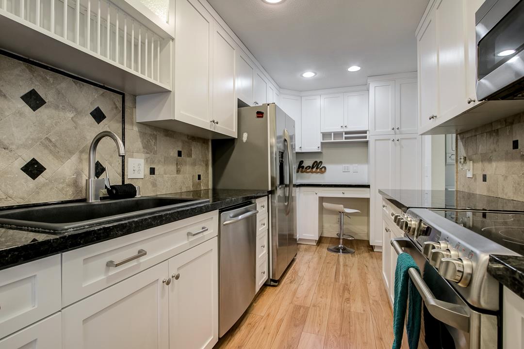 1049 Shell Boulevard, Unit 3 Foster City, CA 94404 - Photo 14 of 56 a kitchen with stainless steel appliances granite countertop a sink a stove and a refrigerator