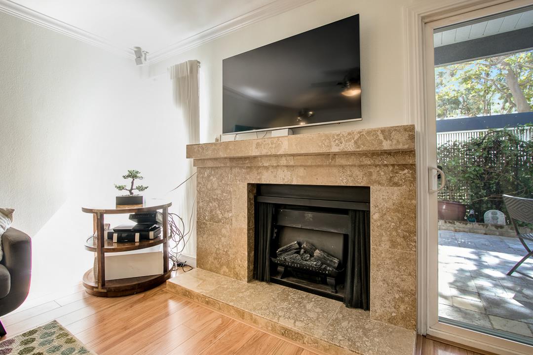 1049 Shell Boulevard, Unit 3 Foster City, CA 94404 - Photo 7 of 56 a living room with a fireplace and a flat screen tv
