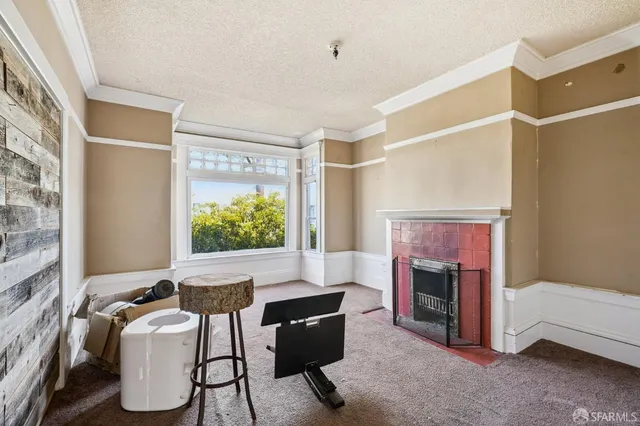a living room with furniture a fireplace and a large window