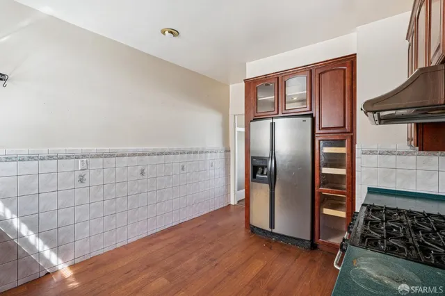 a kitchen with granite countertop a refrigerator and a stove top oven