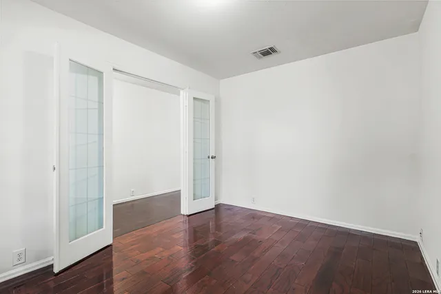 a view of an empty room with wooden floor