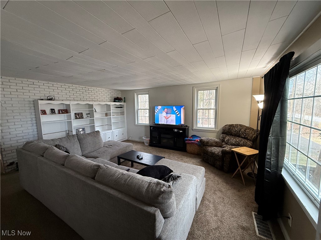 446 Warner Road Southeast Vienna, OH 44473 - Photo 22 of 32 Carpeted living room featuring brick wall