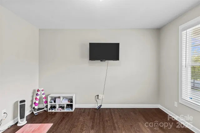 a view of a livingroom with wooden floor and a flat screen tv