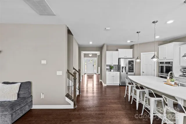 a open kitchen with stainless steel appliances refrigerator dining table and chairs