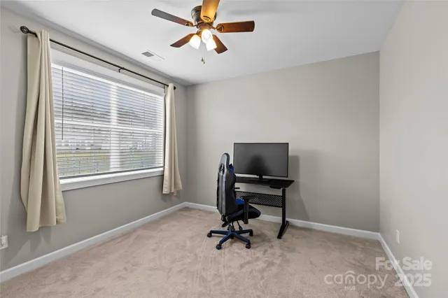 a view of a workspace with furniture and a window