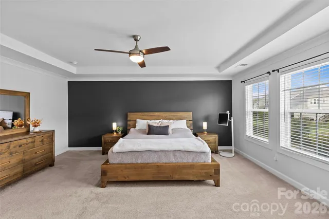 a bedroom with a large bed and a chandelier fan