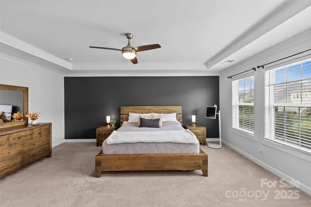 a bedroom with a large bed and a chandelier fan