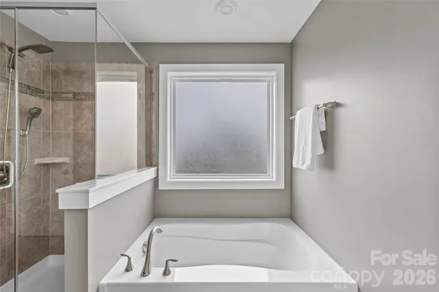 a bathroom with a tub shower and sink