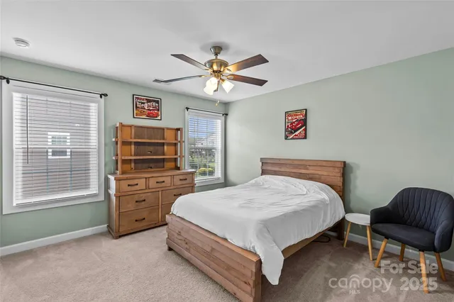 a bedroom with a bed and a chair with the dresser