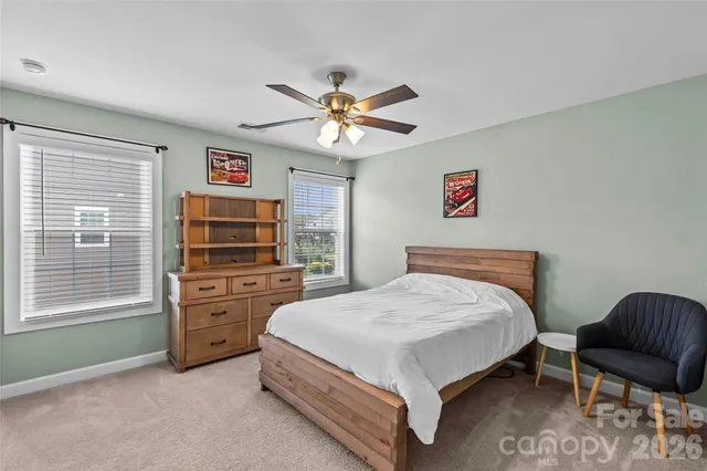 a bedroom with a bed and a chair with the dresser