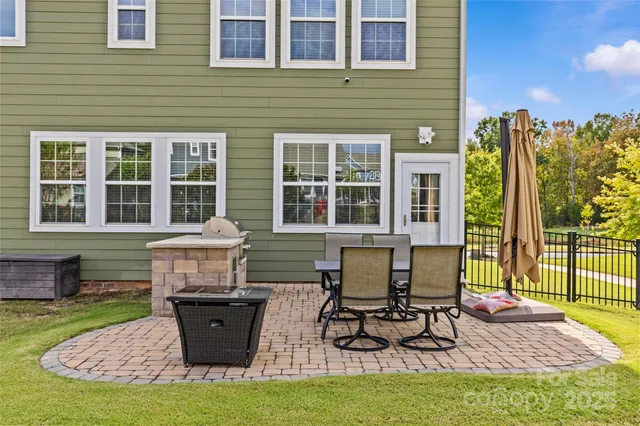 a front view of a house with a garden and chairs