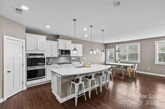 a kitchen with a stove and chairs