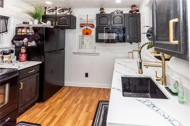 a kitchen with stainless steel appliances kitchen island wooden cabinets and a sink