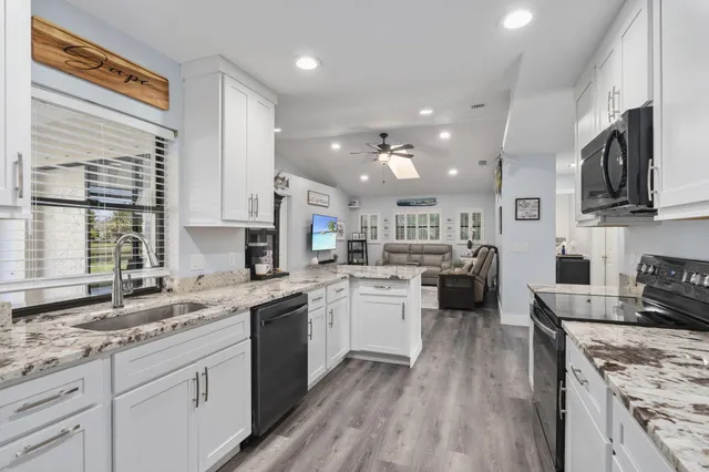 a kitchen with stainless steel appliances granite countertop refrigerator sink and stove