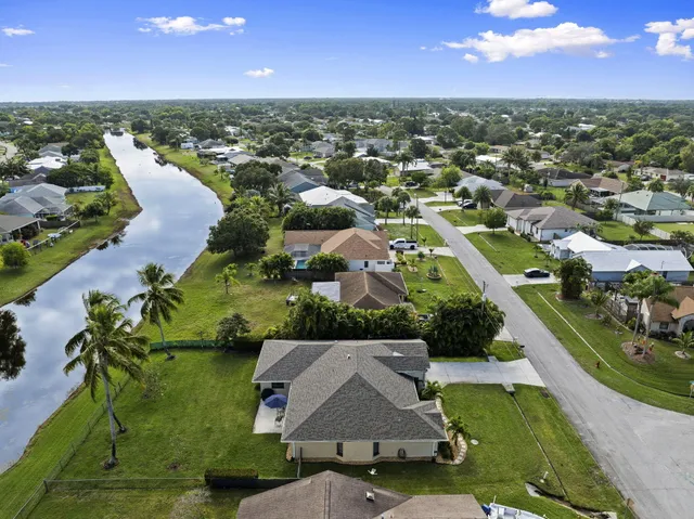 an aerial view of residential houses with outdoor space and lake view