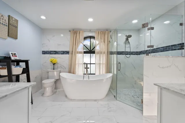 a bathroom with a white bath tub a shower and a sink