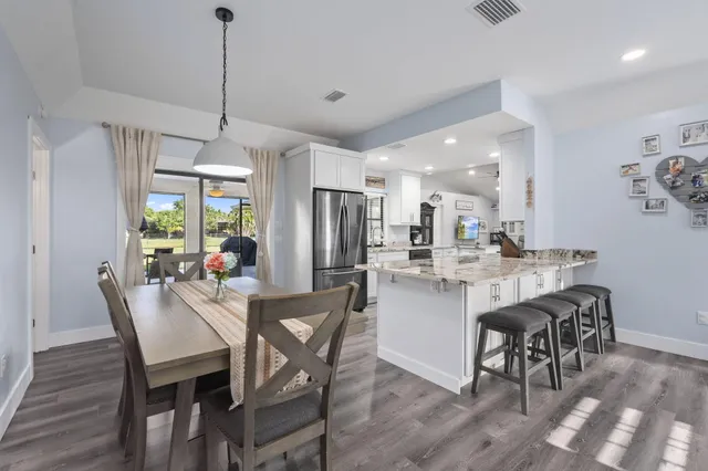 a view of a dining room and livingroom with furniture wooden floor a chandelier