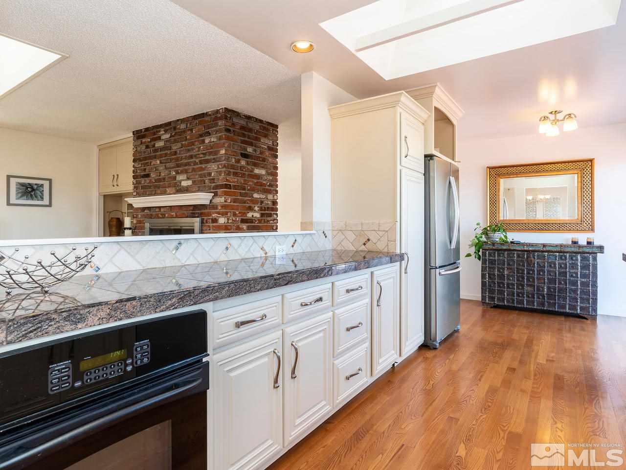 2075 Heatheridge Lane Reno, NV 89509 - Photo 11 of 25 a kitchen with stainless steel appliances kitchen island granite countertop a stove a sink and a refrigerator
