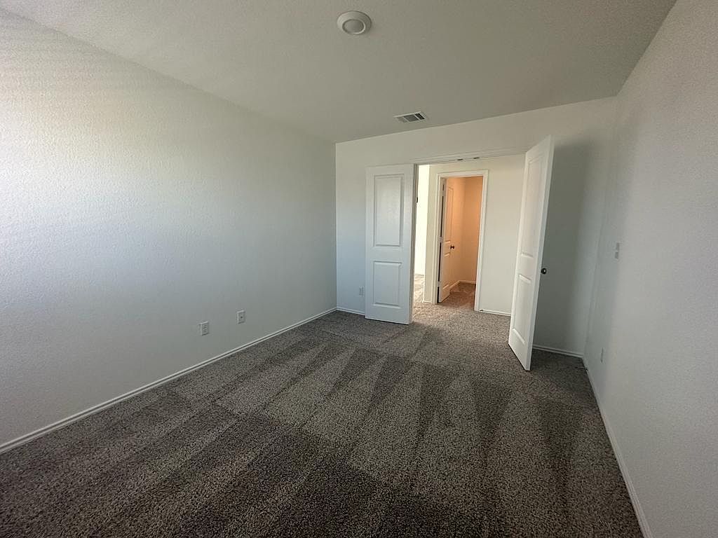 160 River Rise Road Kyle, TX 78640 - Photo 8 of 35 Spacious room featuring textured white walls and speckled grey carpet