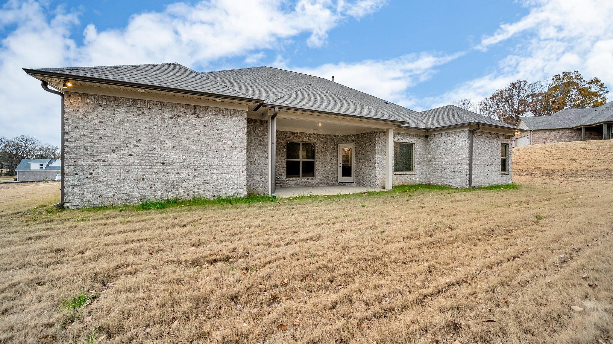 152 York Commons Cove Ripley, TN 38063 - Photo 3 of 39 Back of property featuring a patio area and a lawn
