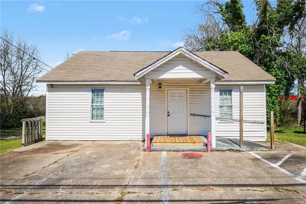 a small white house with a white roof and yard
